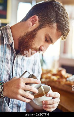 Latte, Kunst und Mann im Café mit Tasse für Morgengetränk, Wellness und Service in der Bäckerei für kleine Unternehmen. Milch, Kaffee und ein professioneller Barista Stockfoto