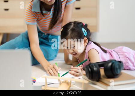 Mutter und Tochter genießen viel Spaß beim gemeinsamen Zeichnen zu Hause Stockfoto