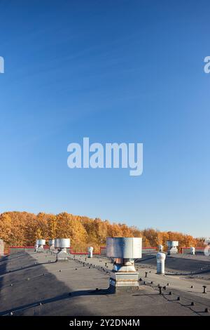 Lüfteranlage für die Lüfteranlage des großen Industriegebäudes. Schornsteinschächte mit Kapuze und Kanäle in Reihe auf dem Dach, selektiver Fokus Stockfoto