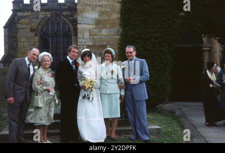 Braut und Bräutigam und Eltern außerhalb der Kirche Juni 1977 Foto aus dem Henshaw-Archiv Stockfoto