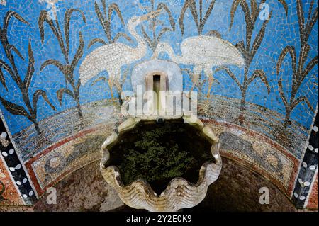 Mosaikbrunnen mit Kranichen, die eine ruhige Szene der Natur und Kunst bieten Stockfoto