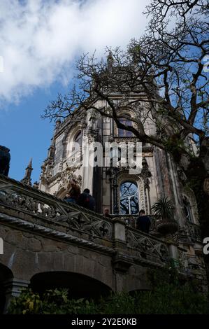 Kunstvolle gotische Turmfassade, eingerahmt von Ästen in der zeitlosen Landschaft von Quinta da Regaleira Stockfoto