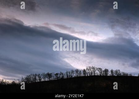 Dunkle Wolken schweben über einem verbrannten Hügel in Legarda, Navarra, Spanien, und verdeutlichen die heftigen Folgen eines Waldbrands. Stockfoto