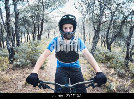 Kaukasischer Teenager im Wald, der Downhill-Radfahren praktiziert. Bargota, Navarra, Spanien, Europa. Sportkonzept. Stockfoto