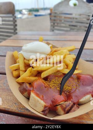 Deutsche Currywurst mit Pommes und Mayonaise Stockfoto