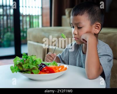 Kinder essen nicht gerne Gemüse, kleiner niedlicher Junge weigert sich, gesundes Gemüse zu essen, Ernährung gesunde Essgewohnheiten für Kinder Konzept, Kinder Stockfoto