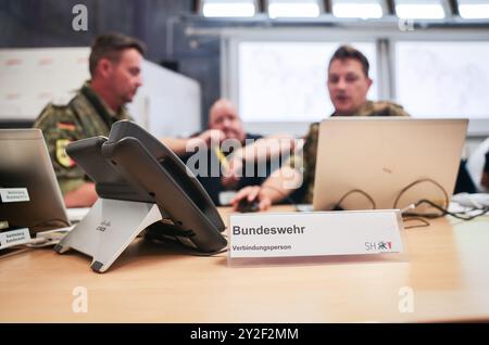 Kiel, Deutschland. September 2024. Mitarbeiter der Bundeswehr im Operationssaal bei einer Presseveranstaltung während der Planungsübung für das Krisenmanagementteam für das Szenario „Ostsee-Sturmflut“. Mit einer Planungsübung bereiten sich Katastrophenschutzbeamte bis Donnerstag in Kiel auf den Einsatz im Falle einer schweren Sturmflut in der Ostsee wie im Oktober vor. Quelle: Christian Charisius/dpa/Alamy Live News Stockfoto