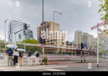 Das Amsterdamer Zuidas Geschäftsviertel mit verschwommenen Menschen- und Verkehrsbewegungen an einem regnerischen Tag, Niederlande Stockfoto