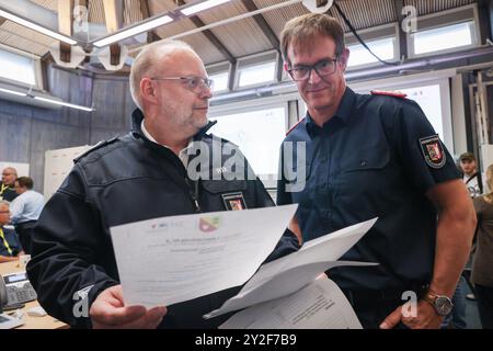 Kiel, Deutschland. September 2024. Dirk Hundertmark (r), Leiter des Referats Krisenmanagement im Innenministerium, und Svend Rix, stellvertretender Leiter des Referats Krisenmanagement und heutiger Übungsleiter, sprechen im Operationssaal bei einer Presseveranstaltung während der Planungsübung für das Krisenreferat zum Szenario "Sturmflut in der Ostsee". Mit einer Planungsübung bereiten sich Katastrophenschutzbeamte bis Donnerstag in Kiel auf den Einsatz im Falle einer schweren Sturmflut in der Ostsee wie im Oktober vor. Quelle: Christian Charisius/dpa/Alamy Live News Stockfoto