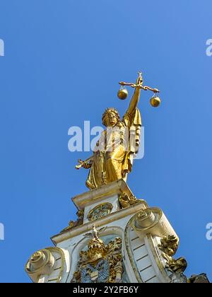 Brügge, Flandern, Belgien - 25. Juni 2024: Nahaufnahme, Statue der Goldenen Richterin auf dem historischen Hofhaus auf dem Burgplatz vor blauem Himmel Stockfoto