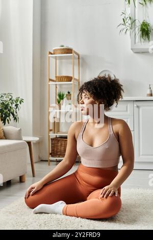 Eine junge Frau genießt einen Moment der Ruhe in ihrem stilvollen Wohnzimmer. Stockfoto