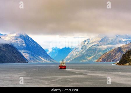 Prince Christian Sound, Grönland - 2. August 2024: Landschaftlich reizvoller Blick auf ein Frachtschiff, das den Fjord des Prince Cristian Sound in Grönland auffährt Stockfoto