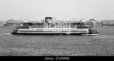 AJAXNETPHOTO. JULI 1975. NEW YORK HARBOUR, USA. - STATEN ISLAND FÄHRE - STATEN ISLAND FÄHRE AUF DEM WEG ZUM BATTERIETERMINAL, MANHATTAN VORBEI AN DER KÜSTE VON NEW JERSEY. FOTO: JONATHAN EASTLAND/AJAX REF:750035 17 80 Stockfoto