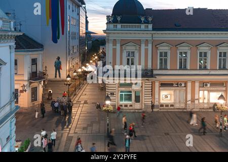 Belgrad, Serbien - 15. September 2019: Menschen, die in der Abenddämmerung die geschäftige Knez Mihailova Straße hinunterlaufen, mit Straßenlaternen, die Gebäude erleuchten Stockfoto