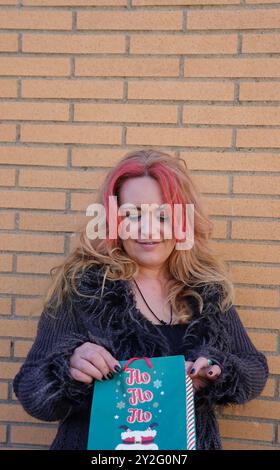 Rote Haarfrau, die auf die weihnachtstasche schaut. Weihnachtstradition Stockfoto