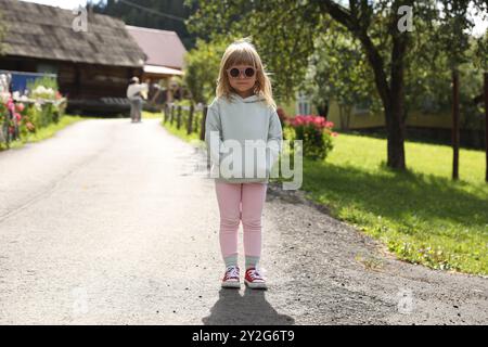 Niedliches kleines Mädchen in stylischer Sonnenbrille draußen Stockfoto