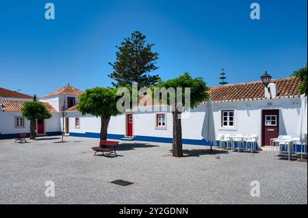 Porto Covo in alentejo Portugal, charmante Kopfsteinpflasterstraße in einem portugiesischen Dorf mit weiß getünchten Häusern. Stockfoto
