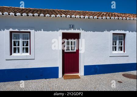 Porto Covo in alentejo Portugal, charmante Kopfsteinpflasterstraße in einem portugiesischen Dorf mit weiß getünchten Häusern. Stockfoto