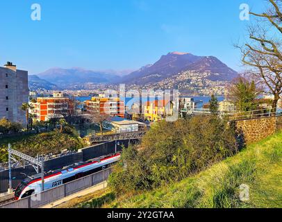 LUGANO, SCHWEIZ - 22. MÄRZ 2022: Der moderne TILO-Personenzug auf dem Bahnhof Lugano-Paradiso gegen die Wohnräume von Lugano, Ceresi Stockfoto