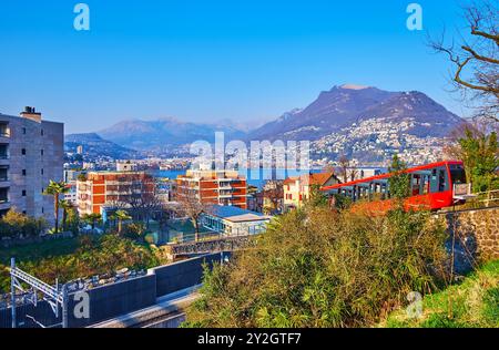 Die malerische Alpenlandschaft mit dem Monte Bre, dem Luganer See und dem roten Oldtimer der Seilbahn Monte San Salvatore im Vordergrund, Paradiso, Lugan Stockfoto