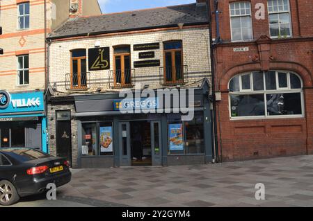 Greggs Bakery und Lab 22 Cocktailbar darüber in der Caroline Street. Cardiff, Wales, Vereinigtes Königreich. Juli 2024. Stockfoto