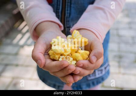 Popcorn in den Kinderhänden Stockfoto