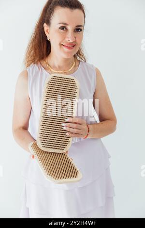 Frau, die Nagelbrett für Yoga-Massage hält Stockfoto