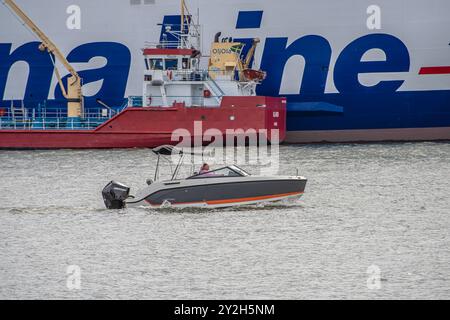 Göteborg, Schweden - 4. Mai 2022: Motorboot fährt vor einer Fähre und einem Öltanker den Fluss hinunter. Stockfoto