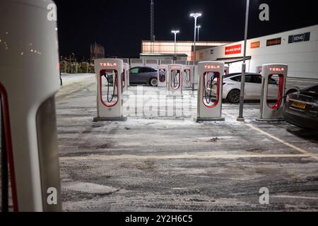 Göteborg, Schweden - dezember 09 2022: Autos laden nachts an Tesla Supercharger auf Stockfoto