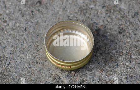 Goldener Flaschendeckel auf dem Gehweg Stockfoto