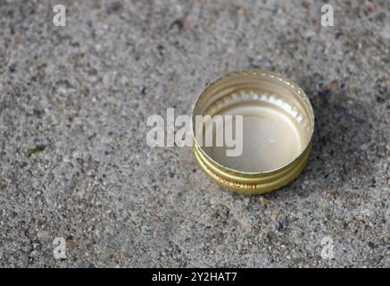 Goldener Flaschendeckel auf dem Gehweg Stockfoto