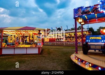 Fahrgeschäfte, Spiele und Attraktionen auf einem Wandermarkt in Saffron Walden, Essex, Großbritannien Stockfoto