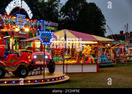 Eine Reihe von Vergnügungsfahrten, Spielen und Attraktionen auf einem Wanderfundus in Saffron Walden, Essex, Großbritannien Stockfoto