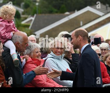 Llanelli, Wales UK 10. September 2024 HRH Prinz William, Prince of Wales begrüßt Wohlwollende vor der Swiss Valley Primary School, wo er Schüler traf, die 2024 am Urdd Eisteddfod teilnahmen, einem einwöchigen Festival, das die walisische Sprache und Kultur feiert. Seine Reise nach Llanelli in Südwales beinhaltete auch einen Besuch der Wales Air Ambulance, deren Schirmherr er ist, und Parc y Scarlets, der Heimat der Scarlets Rugby Union. Stockfoto