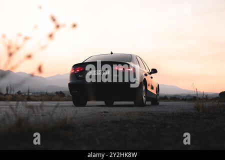 Bulgarien - 10 02 2024: Rückansicht eines schwarzen Audi s4 mit wunderschönem Sonnenuntergang im Hintergrund. Flachwinkelansicht. Stockfoto