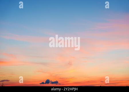 Ein atemberaubender, lebendiger Sonnenuntergangshimmel mit warmen Farben und Stratuswolken über dem Horizont Stockfoto