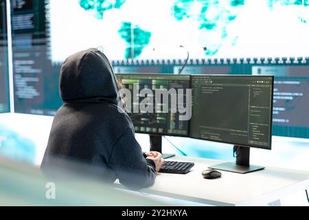 Cyber Intelligence Specialist untersucht Daten auf einem großen Bildschirm in einer Regierungsbehörde und konzentriert sich dabei auf Cyberabwehr und Schutz vor Cyberangriffen. Private Informationen im Hybridkrieg. Stockfoto