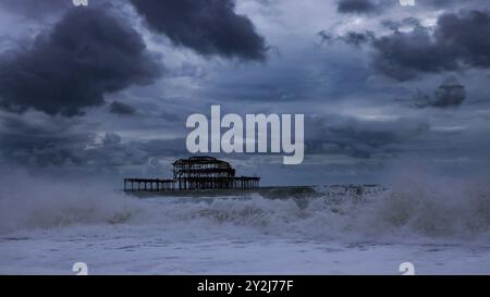 Brighton, Großbritannien. September 2024. Ein grauer und stürmischer Tag am Strand in Brighton, mit Wellen, die um die Überreste des alten West Pier und des Strandes krachen. Quelle: Imageplotter/Alamy Live News Stockfoto