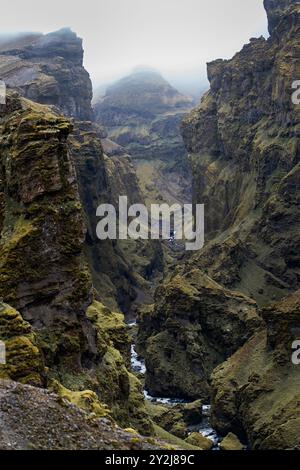 Atemberaubende Berge mit kaskadierenden Wasserfällen, die durch den üppigen Múlagljúfur Canyon in Islands rauer Landschaft fließen Stockfoto