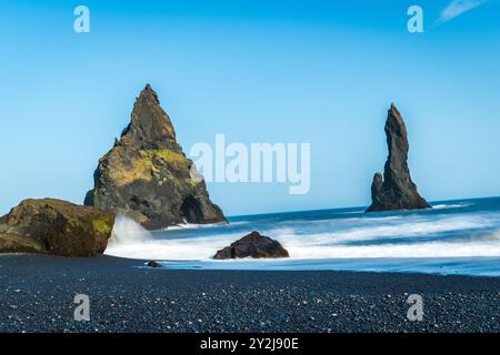 Der dramatische Strand von Reynisfjara besticht durch schwarzen vulkanischen Sand und hoch aufragende Basaltmeerstapel, die sich aus dem wilden Atlantik in Island erheben Stockfoto