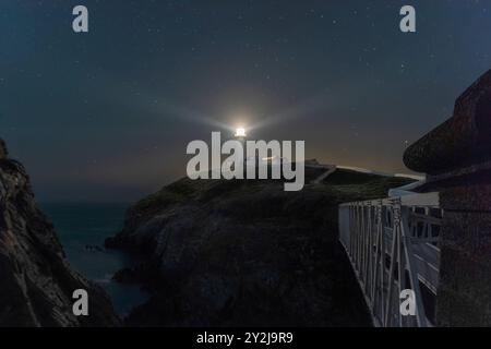 UK, Anglsey - September 202: Leuchtturm, warnende Schifffahrt an der felsigen Küste Stockfoto