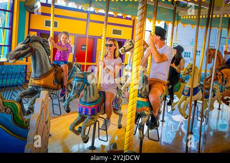Familienreiten, traditioneller Pferdekarussell, fröhlicher Rundgang Stockfoto