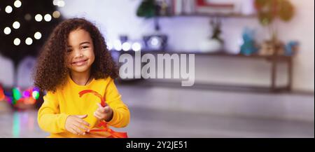 Cute afrikanisches Mädchen öffnen Weihnachtsgeschenk zu Hause Stockfoto