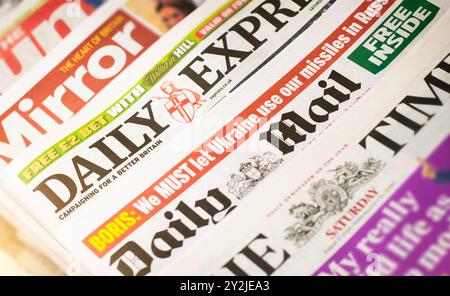 Schlagzeilen von Boulevardzeitungen aus dem Vereinigten Königreich am Zeitungskiosk. Zu den britischen Printpublikationen gehören The Sun, Daily Mirror, The Times, Daily Mail A Stockfoto