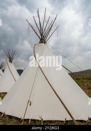 Die Klappe läuft an bewölktem Tag an der Seite des großen weißen Tipis hoch Stockfoto