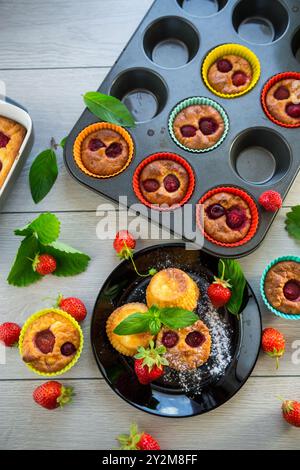Süße Quark-Muffins mit Erdbeerfüllung, auf einem Teller auf einem Holztisch. Stockfoto