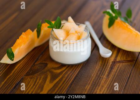 Süßer hausgemachter Joghurt im Glas mit reifem Melonenstück. Stockfoto