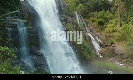 Majestätischer Wasserfall, der über zerklüftete Klippen in den üppigen Wald unter sich hinunter stürzt Stockfoto