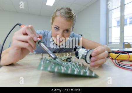 Junge Frau in einem Servicezentrum für Elektronikreparaturen Stockfoto