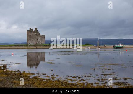 Die Burg Lochranza spiegelt sich bei Ebbe in den stillen Gewässern des Hafens Lochranza. Lochranza ist ein kleines Dorf und Fährhafen auf der Insel Arran. Stockfoto